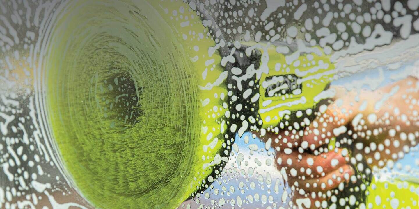 Close up of RYOBI power scrubber cleaning other side of glass