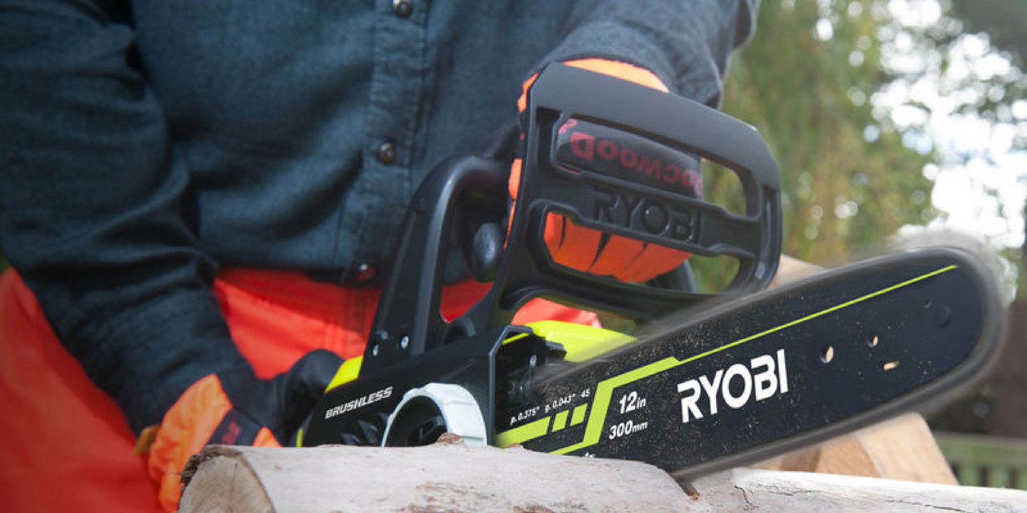 A Ryobi chainsaw cutting through a smooth tree branch