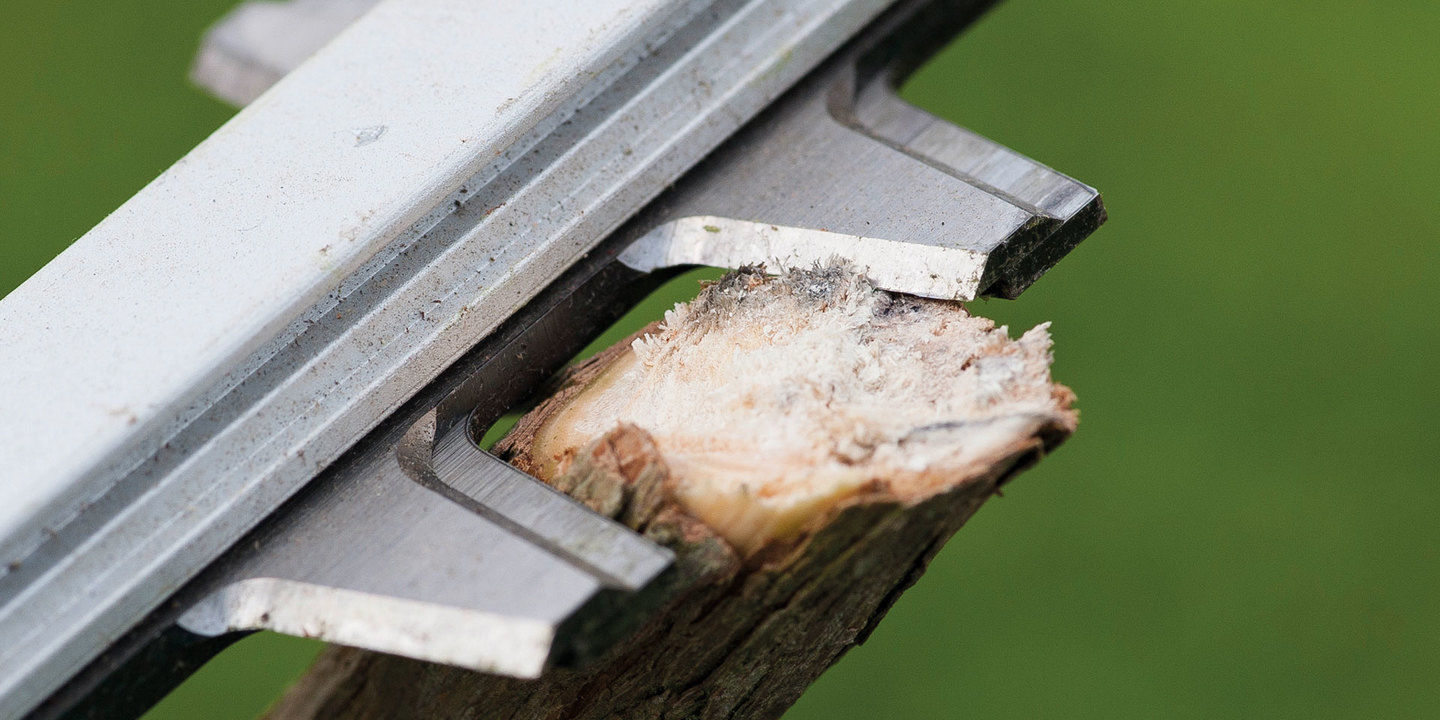 A close up of the blades of a Ryobi hedge trimmer