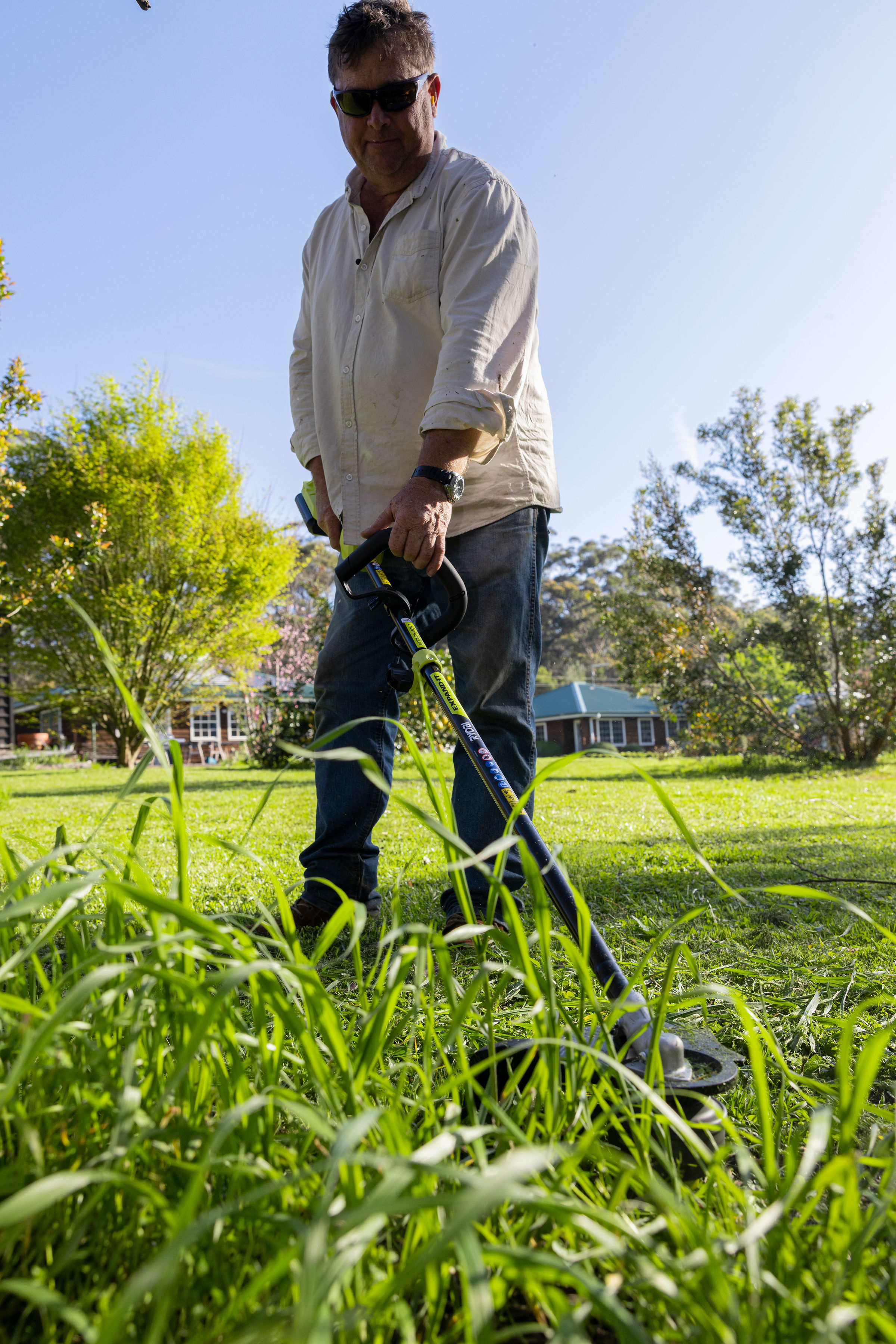 Jason Hodges uses a RYOBI Line Trimmer to trim long grass