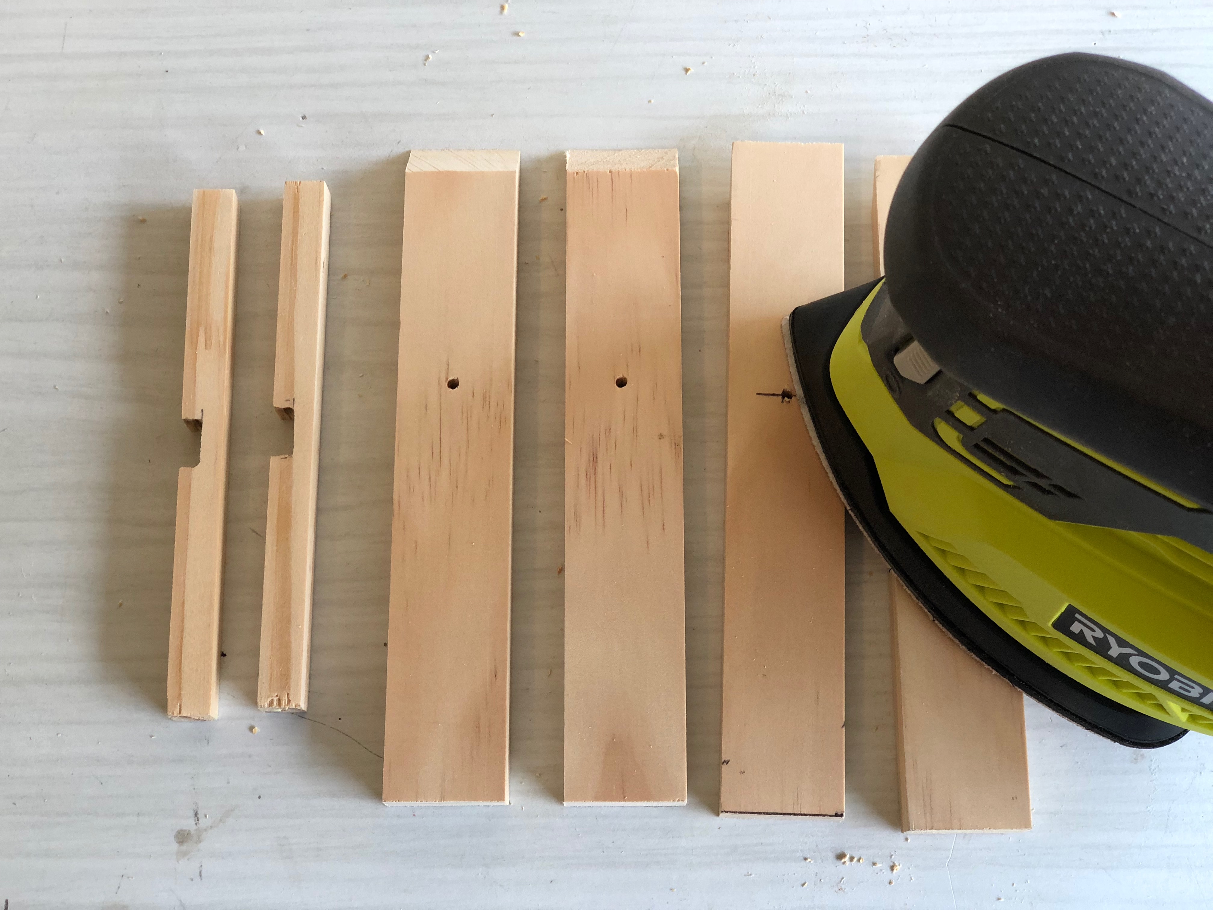 A Ryobi palm sander used to smooth pieces of pine