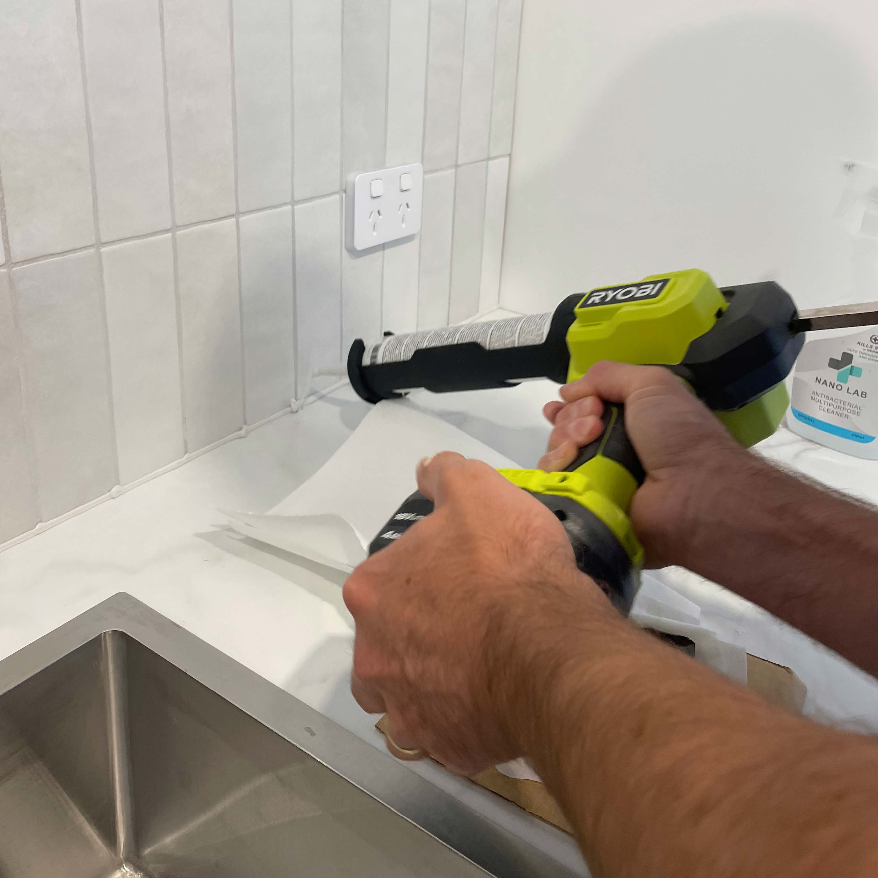 Using a RYOBI Caulking Gun to seal gap between wall tiles and benchtop