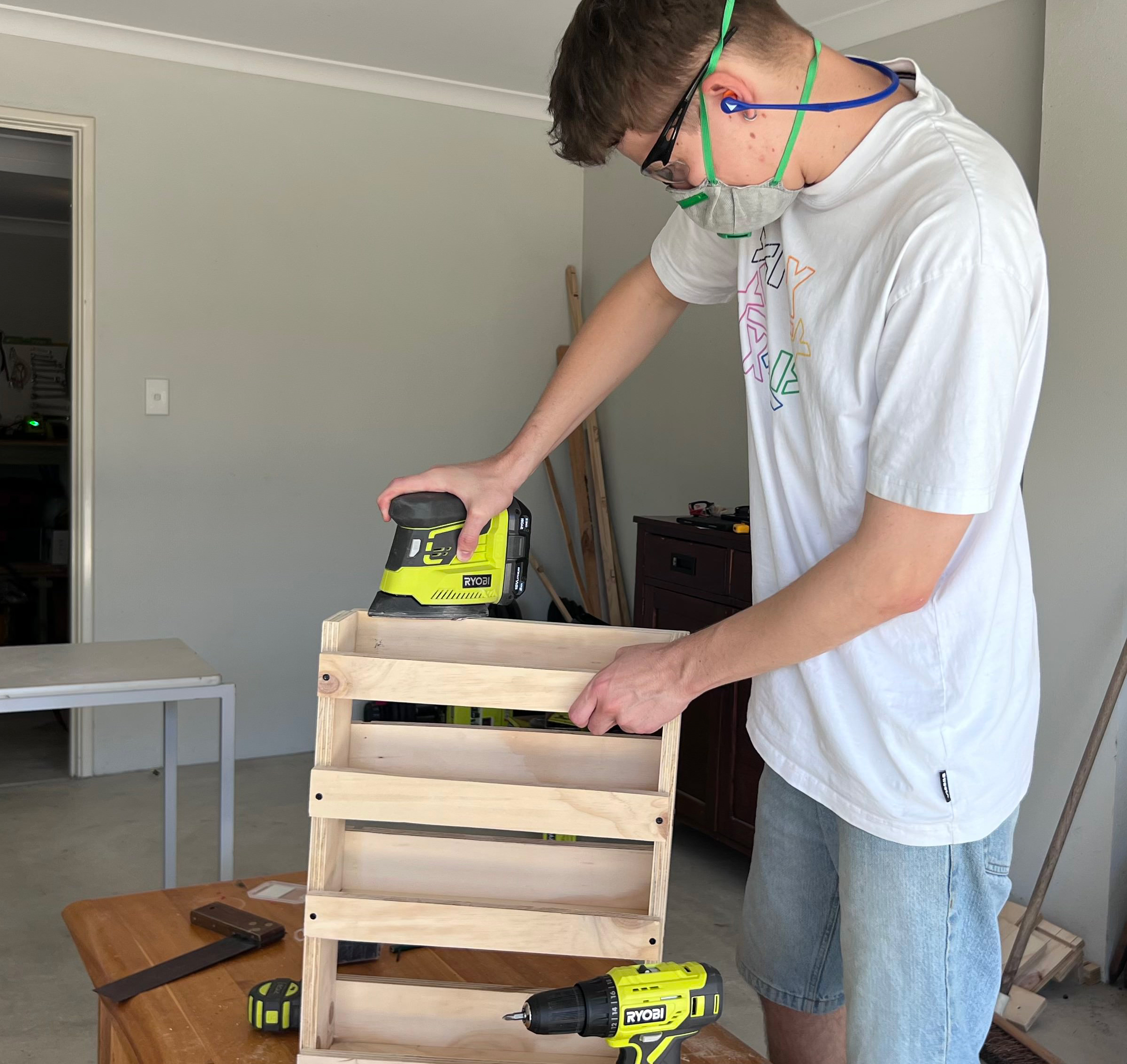 Using a RYOBI palm sander to finish a DIY spice rack