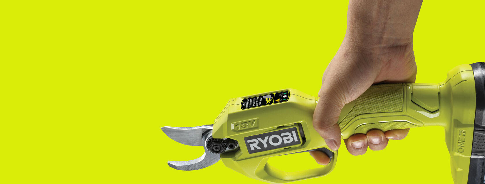 Side view of hand with RYOBI secateurs on a hyper green background 