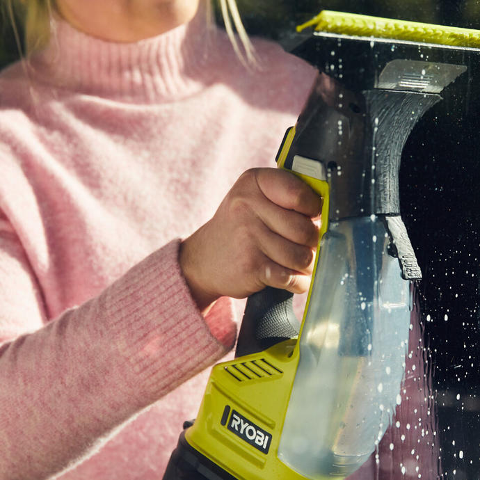 A woman using a Ryobi Window Vac to clean glass