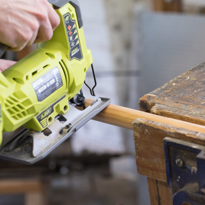 A Ryobi jigsaw being used to cut a dowel to size